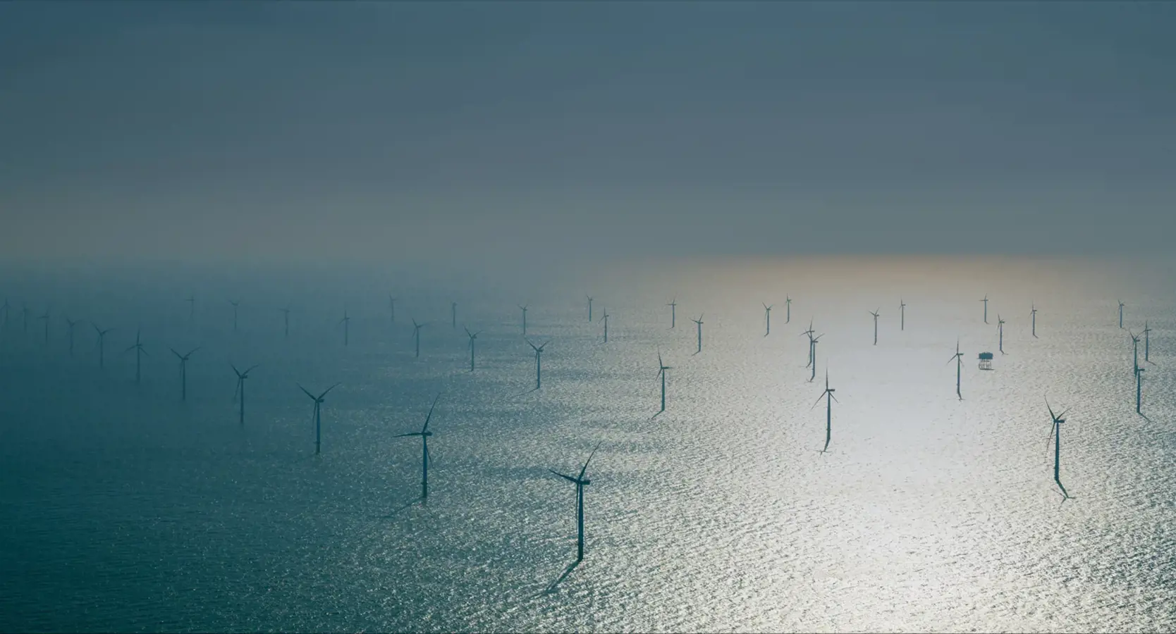 An image of Vineyard Wind 1. The image displays multiple windmills situated in the ocean.